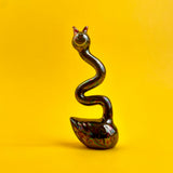 A ceramic black swan figurine with an exaggeratedly long and wiggly neck. 