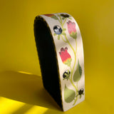 An arched ceramic wall shelf featuring an illustration of a stylized Atropa Belladonna plant. Side view 2